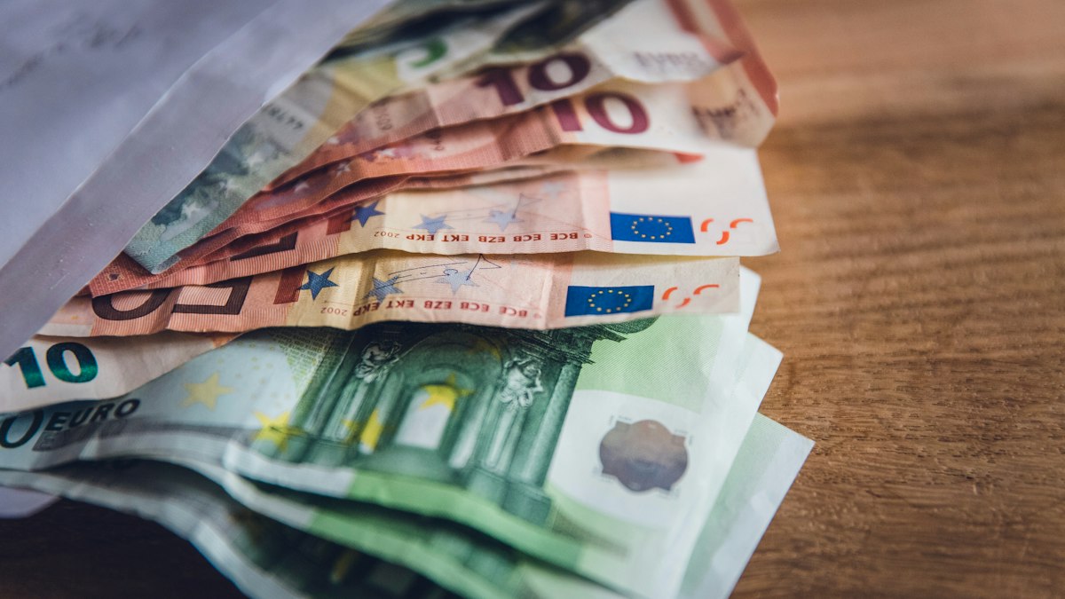 Factura en euros sobre una mesa junto a un portátil y una calculadora