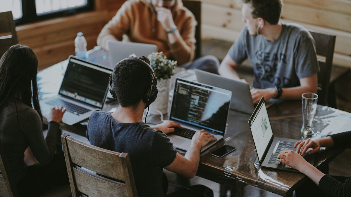 Equipo pequeño trabajando con portátiles en una oficina