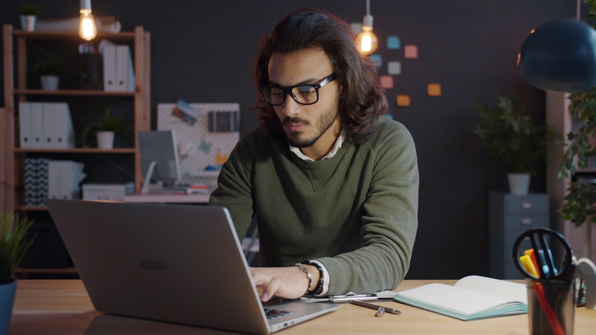 Persona trabajando en el portátil por la tarde en una oficina en casa