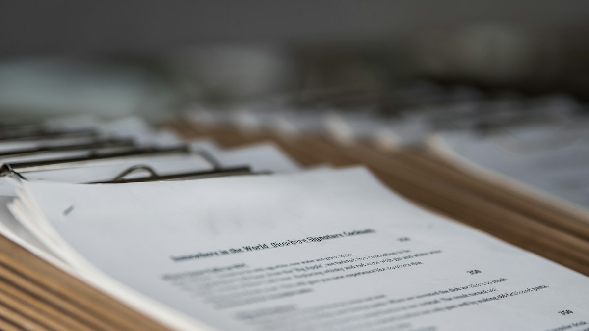 Documentos legales sobre una mesa junto a un portátil