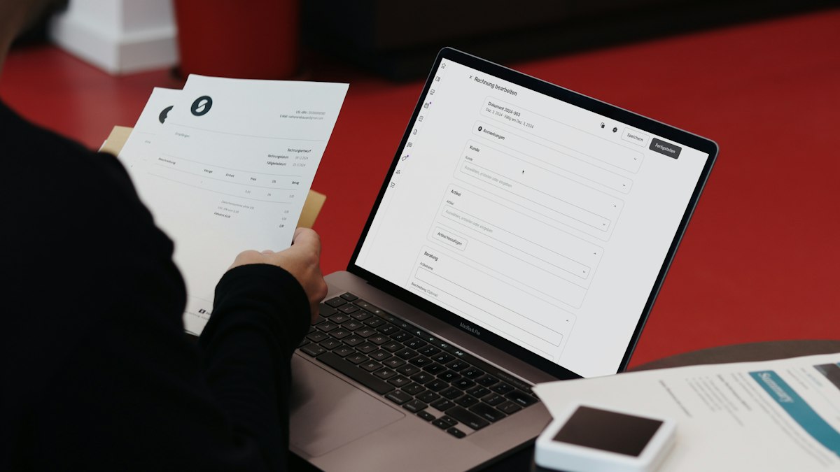 Factura de suscripción de software abierta en un portátil sobre una mesa de trabajo